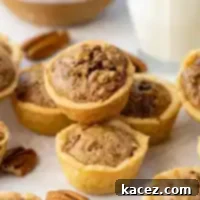 Bite-Sized Pecan Perfection 10 Several pecan tassies on a white surface.