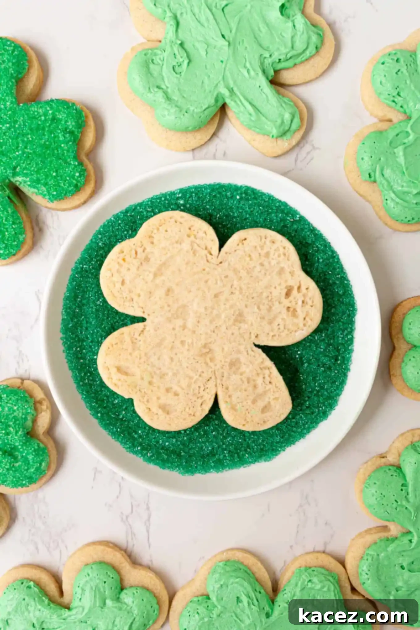Close-up of a frosted shamrock cookie being dipped generously into a bowl of vibrant green sanding sugar.