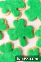Several frosted and decorated shamrock cookies.