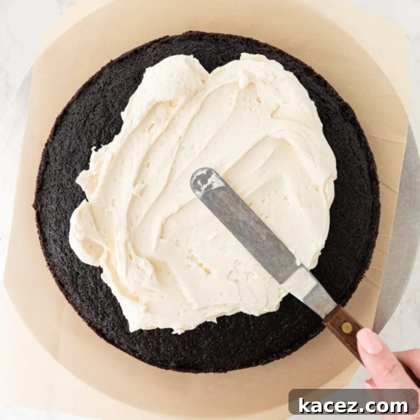 Guinness Chocolate Dream Cake 6 A layer of chocolate cake being generously frosted with creamy Baileys buttercream.